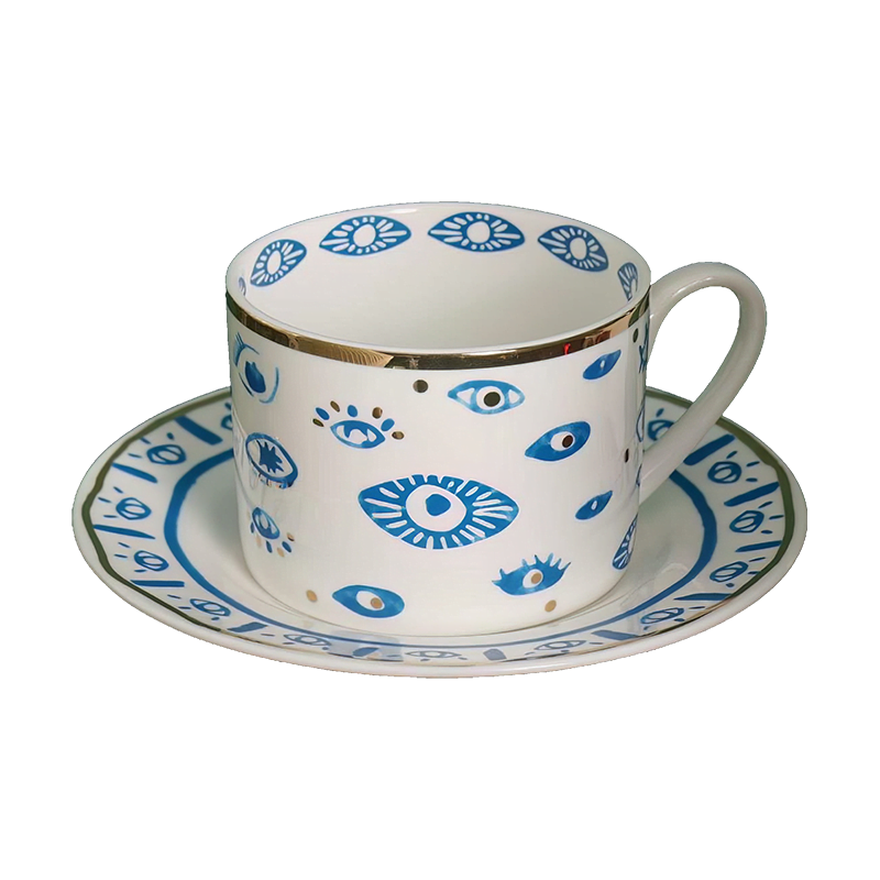 An Evil Eye Blessing Set cup and saucer with a blue and white design.
