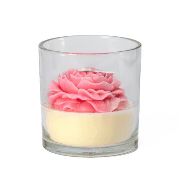 A rose candle in a glass jar features a pink and white flower-shaped wax design.