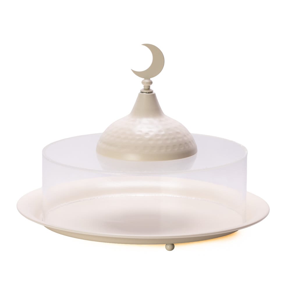 Round cream metal serving platter with a clear acrylic dome cover featuring a hammered gold-tone handle topped with a crescent moon.